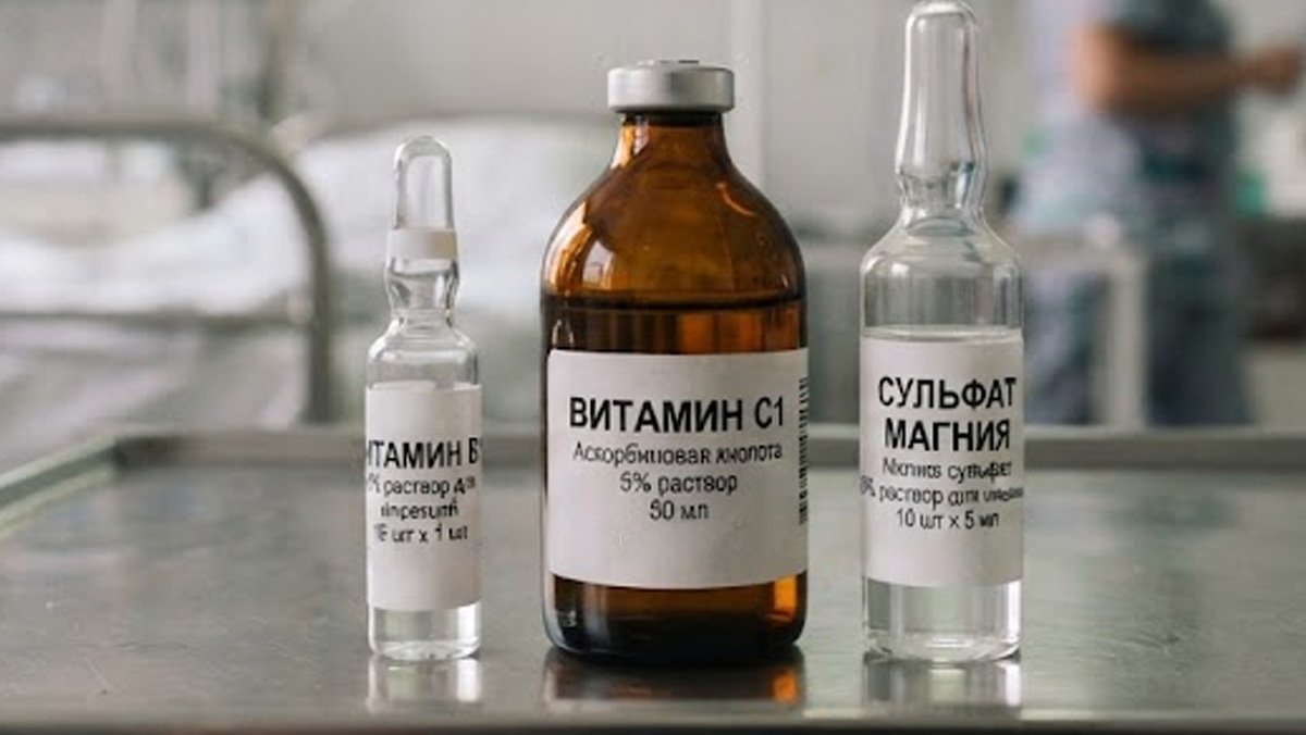 Ампулы с витаминами и сульфатом магния на металлическом столике в палате.